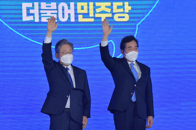 더불어민주당 제20대 대통령 후보에 선출된 이재명 경기지사가 10월 10일 서울 송파구 올림픽공원 SK올림픽핸드볼경기장에서 열린 서울 합동연설회에서 후보자 수락 연설을 앞두고 두 손을 올려 인사하고 있다. 오른쪽은 이낙연 전 민주당 대표. [원대연 동아일보 기자]