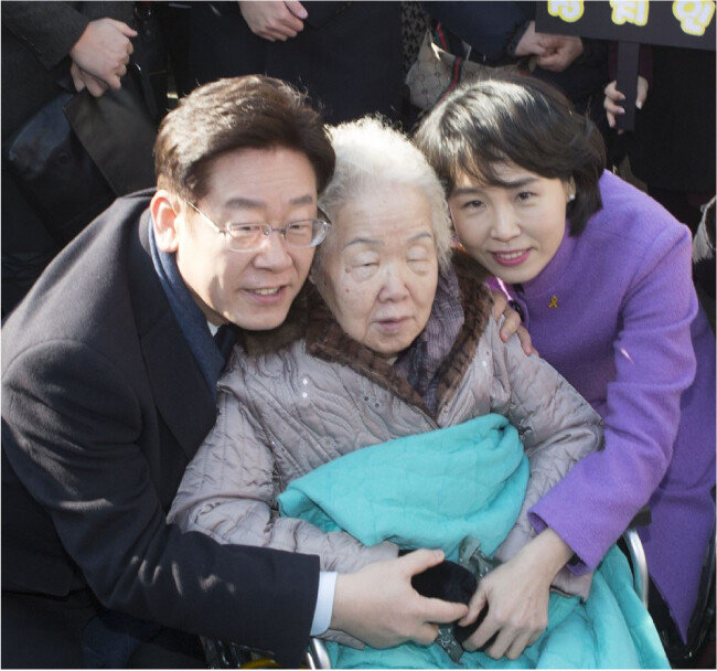 이재명 더불어민주당 대통령 후보는 어려서 어머니의 사랑을 많이 받았지만 아버지의 지지는 많이 받지 못했다. 2017년 대선에 나섰던 이 후보가 소년공으로 일했던 성남 오리엔트시계 사옥에서 출마 선언에 앞서 아내와 함께 어머니를 안아주고 있다. [동아일보]
