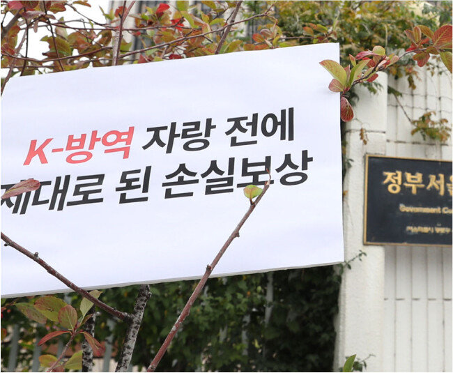 10월 8일 전국자영업자협의회, 한국중소상인자영업자총연합회, 참여연대 등이 정부서울청사 앞에서 코로나19 자영업자 100% 손실보상을 촉구하는 기자회견을 연 가운데, ‘제대로 된 손실보상’이라는 문구가 적힌 피켓이 보인다. [김재명 동아일보 기자]