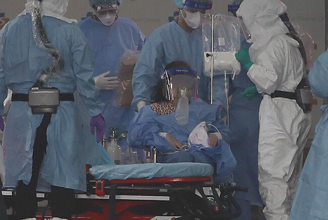 2021년 12월 14일 오후 서울 중랑구 서울의료원 의료진이 코로나19 환자를 이송하고 있다. [뉴스1]