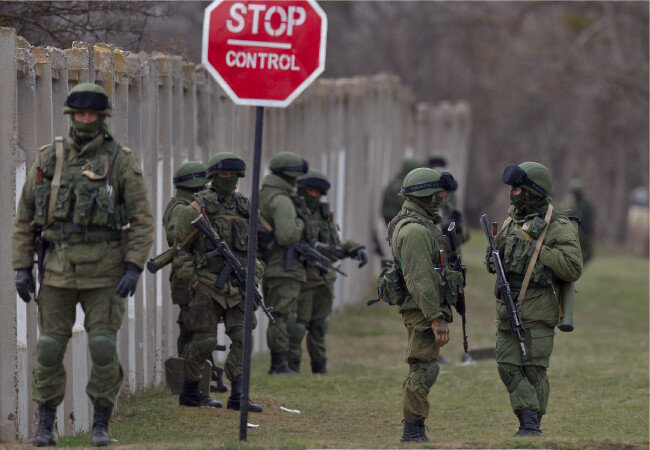 2014년 3월 19일 크림반도 페레발네의 우크라이나 군부대 외곽에서 친러시아 군인들이 경계 자세를 취하고 있다. 블라디미르 푸틴 러시아 대통령이 크림 자치공화국을 자국 영토로 통합하는 조약에 서명한 후 하루 만에 친러시아 병력이 우크라이나 해군본부를 급습했으며, 당시 우크라이나 군인들은 별다른 저항을 하지 않았다. [AP=뉴시스]