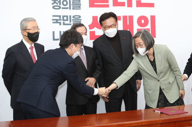 이준석 국민의힘 대표(왼쪽)와 이수정 당시 국민의힘 공동선대위원장(경기대 교수)이 2021년 12월 7일 서울 여의도 국회에서 열린 이용호 무소속 의원 입당식에서 악수하고 있다. [사진공동취재단]