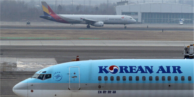 2021년 12월 29일 서울 김포공항 계류장에서 대한항공과 아시아나항공 소속 여객기가 이륙 준비를 하고 있다. 공정거래위원회는 이날 대한항공의 아시아나항공 인수합병  ‘조건부 승인’ 결정을 내렸다.  [뉴스1]