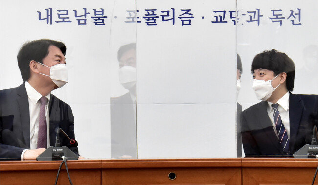 2021년 6월 16일 이준석 국민의힘 대표(오른쪽)가 서울 여의도 국회에서 안철수 국민의당 대표를 예방해 가림막을 사이에 두고 대화하고 있다. [뉴스1]