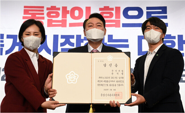 3월 10일 윤석열 대통령 당선인이 중앙선거관리위원회로부터 받은 당선증을 청년보좌역에게서 전달받은 뒤 기념촬영을 하고 있다. [뉴스1]