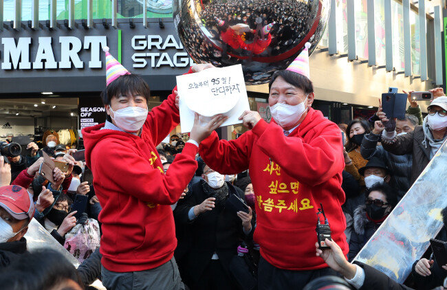 2021년 12월 4일 윤석열 당시 국민의힘 대선후보와 이준석 당대표가 부산 서면 일대에서 거리 인사 도중 부산시당에서 전달한 케이크를 들어 보이고 있다. [국민의힘 선대위]
