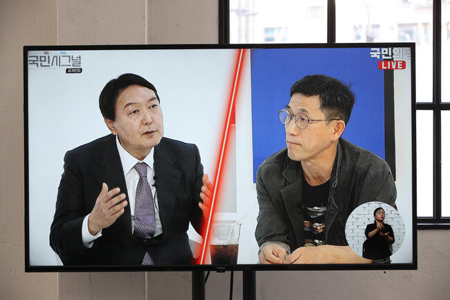 지난해 9월 10일 서울 금천구 즐스튜디오에서 열린 국민의힘 대선 경선 후보 ‘국민 시그널 면접’에 참가한 윤석열 당시 후보가 진보논객 진중권 전 동양대 교수의 질문에 답변하는 모습이 현장에서 중계되고 있다. [사진공동취재단]