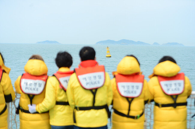 세월호 참사 8주기를 엿새 앞둔 4월 10일 오전 전남 진도군 동거차도 앞 세월호 침몰 해역에서 선상 추모식이 열린 가운데 유가족들이 사고 해역을 알리는 노란부표를 바라보고 있다. [뉴스1]