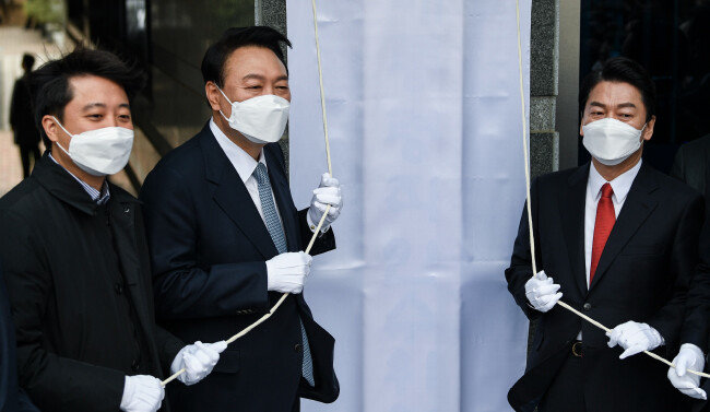 제20대 대통령직인수위원회가 공식 출범한 3월 18일 윤석열(가운데) 대통령 당선인, 안철수(오른쪽) 인수위원장, 이준석 국민의힘 대표가 서울 종로구 삼청동 인수위 사무실에서 열린 현판식에 참석하고 있다. [사진공동취재단]