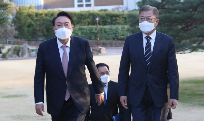 문재인 대통령과 윤석열 대통령 당선인(왼쪽)이 3월 28일 청와대 상춘재에서 만찬 회동을 하기 위해 녹지원을 가로질러 걸어가고 있다. [청와대 사진기자단]