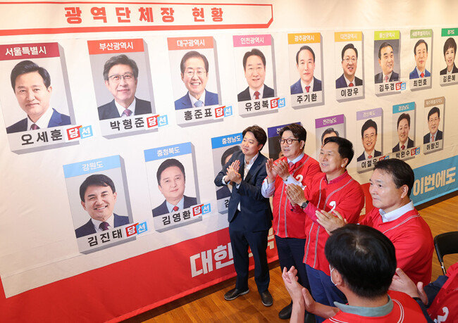 이준석 국민의힘 대표와 권성동 원내대표(왼쪽부터) 등 당 지도부가 6월 1일 서울 여의도 국회도서관에 마련된 개표상황실에서 당선이 확실시 된 후보들 사진에 스티커를 붙인 뒤 박수를 치고 있다. [뉴스1]