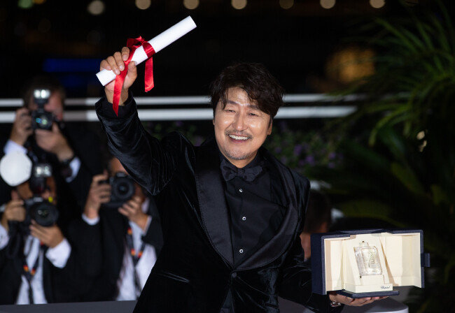 배우 송강호가 5월 28일(현지 시간) 제75회 칸 국제영화제 폐막식에 참석해 남우주연상 트로피를 들어 보이고 있다. [뉴스1]