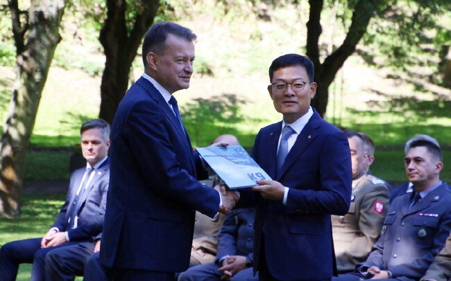 7월 27일 손재일 한화디펜스 대표이사(오른쪽)와 마리우스 브와슈차크 폴란드 국방장관이 폴란드 바르샤바에서 K-9 자주포, K-10 탄약운반장갑차, K-11 사격지휘장갑차 등을 수출하기 위한 기본계약을 체결하고 있다. [뉴스1]