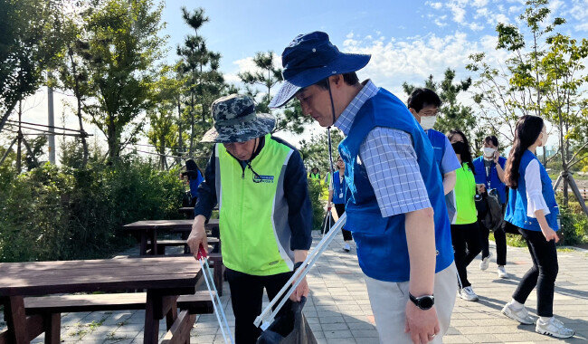 9월 인천 경인아라뱃길에서 김춘안 NH농협은행 부행장(왼쪽)과 안병옥 한국환경공단 이사장(오른쪽)을 비롯한 두 기관 임직원들이 플로깅(Plogging) 환경 정화활동을 하고 있다. [NH농협은행]