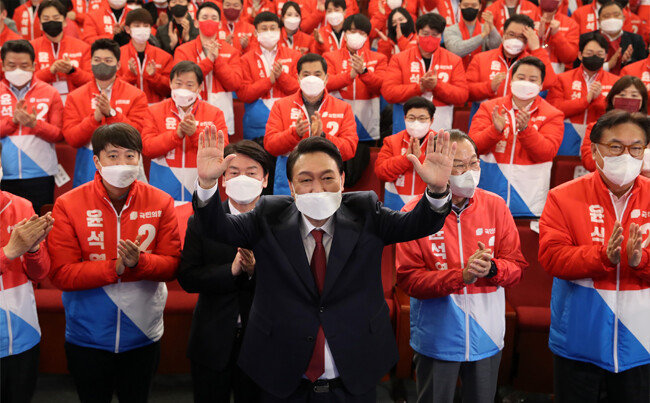 2022년 5월 10일 윤석열 당시 대통령 당선인이 서울 여의도 국회도서관에 마련된 개표상황실을 찾아 당선 세리머니를 하고 있는 가운데, 그 뒤로 이준석 당시 국민의힘 대표(왼쪽 첫 번째)와 안철수 당시 국민의당 대표(왼쪽 두 번째)의 모습이 보인다. [사진공동취재단]
