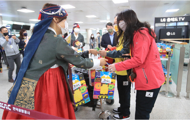 지난해 12월 25일 제주-타이베이 직항노선을 타고 제주를 찾은 대만 관광객들이 제주관광공사 직원으로부터 환영받고 있다. 제주-타이베이 직항노선은 2020년 2월 이후 2년 9개월 만에 이날 재개됐다. [뉴스1]