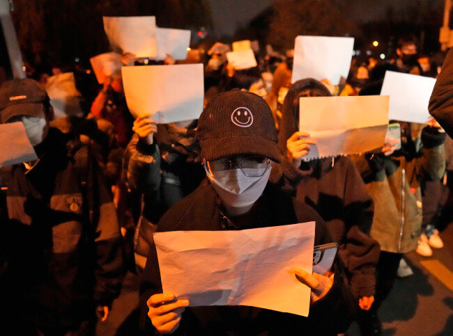 2022년 11월 27일(현지 시간) 중국 베이징에서 중국 정부의 신종 코로나바이러스 감염증 봉쇄 정책인 ‘제로 코로나’에 항의하는 시위에 나선 시민들이 아무것도 쓰여 있지 않은 A4 용지 백지를 들고 있다. [베이징=AP 뉴시스]