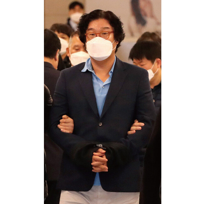 해외 도피 중 태국에서 붙잡힌 김성태 전 쌍방울그룹 회장(가운데)이 1월 17일 인천공항을 통해 귀국하고 있다. [사진공동취재단]