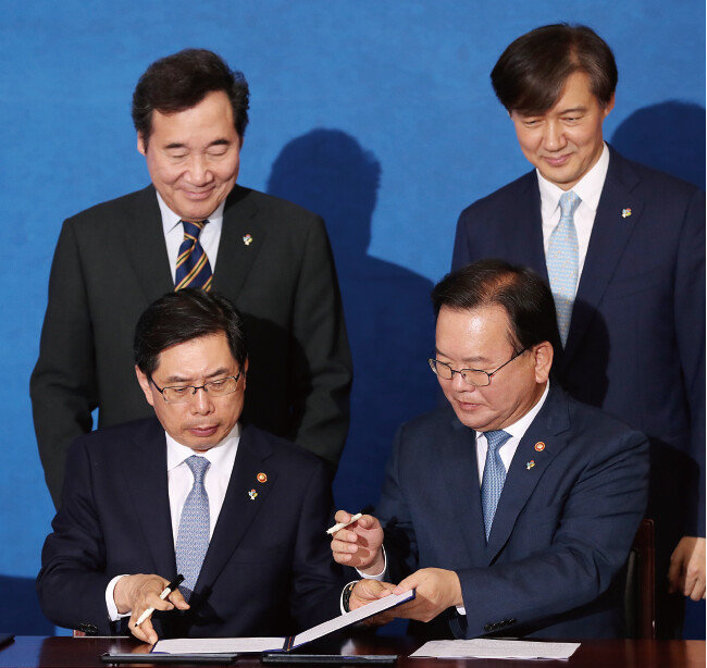 2018년 6월 21일 박상기 당시 법무부 장관(앞줄 왼쪽)과 김부겸 행정안전부 장관(앞줄 오른쪽)이 이낙연 국무총리(뒷줄 왼쪽)와 조국 대통령민정수석비서관이 지켜보는 가운데 정부서울청사 별관에서 검·경 수사권 조정 합의문에 서명하고 있다. [동아DB]