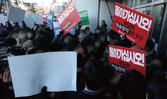 2022년 1월 14일 국민의힘 의원들이 서울 마포구 상암동 MBC 사옥 앞에서 윤석열 당시 국민의힘 대선후보의 배우자 김건희 씨의 ‘7시간 통화 녹취록’ 보도를 예고한 MBC를 항의 방문한 가운데, MBC 노조원들과 대치하고 있다. [사진공동취재단]