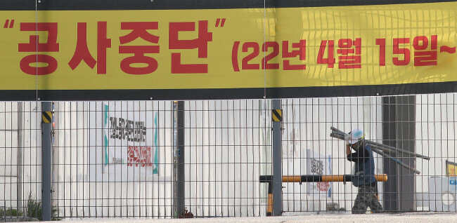 지난해 4월 15일 둔촌주공 시공사업단은 재건축조합과 공사비로 갈등을 겪은 끝에 공사 중단을 선언했다. 사진은 같은 해 4월 11일 재건축 현장에 공사 중단 예고 현수막이 걸려 있는 모습. [뉴스1]