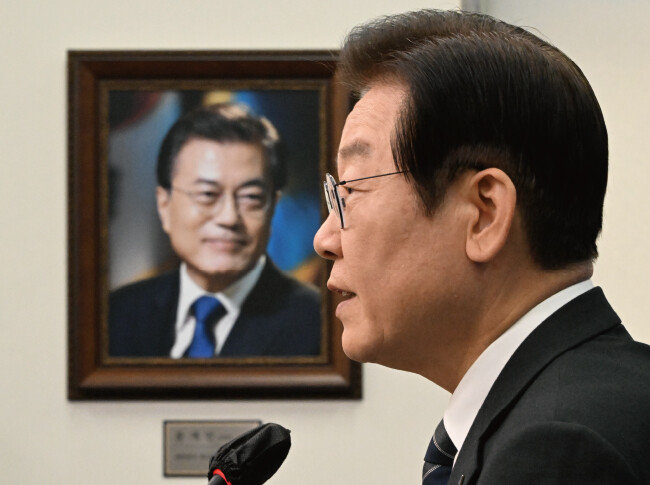 이재명 더불어민주당 대표가 지난해 10월 21일 서울 여의도 국회에서 기자회견을 하고 있다. 옆으로 문재인 전 대통령의 사진이 보인다. [사진공동취재단]