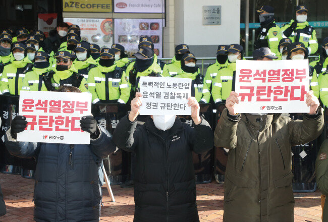 1월 18일 국가정보원과 경찰청이 서울 중구 민주노총 본부 사무실에 대한 압수수색을 하는 사이 건물 밖에서 민주노총 노조원 등이 피켓 시위를 하고 있다. [김동주 동아일보 기자]