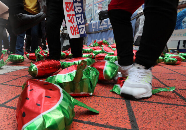 3월 3일 서울 영등포구 여의도동 더불어민주당 당사 앞에서 이재명 대표 지지자들이 수박 풍선을 밟아 터뜨리는 퍼포먼스를 벌이고 있다. [뉴시스]