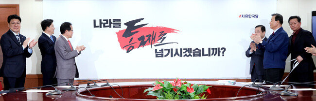 2018년 4월 25일 홍준표 당시 자유한국당 대표(왼쪽에서 세 번째)와 장제원 수석대변인(왼쪽에서 첫 번째) 등이 서울 여의도 당사에서 지방선거 슬로건을 공개하고 있다. 이날 홍 대표는 페이스북에 “‘나라를 통째로 북한과 좌파들에게 넘기고 지방까지 통째로 넘기겠습니까’라는 것이 이번 지방선거의 구호”라고 썼다.