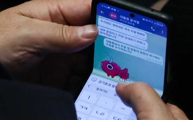2022년 7월 26일 국회 본회의장에서 개최된 대정부질문 도중 국민의힘 권성동 당대표 직무대행 겸 원내대표가 휴대전화로 윤석열 대통령과 대화를 나누는 모습. 윤 대통령이 국민의힘 이준석 대표를 향해 “내부 총질이나 하던 당대표”라고 쓴 메시지 등이 포착돼 논란이 일었다. [동아DB]