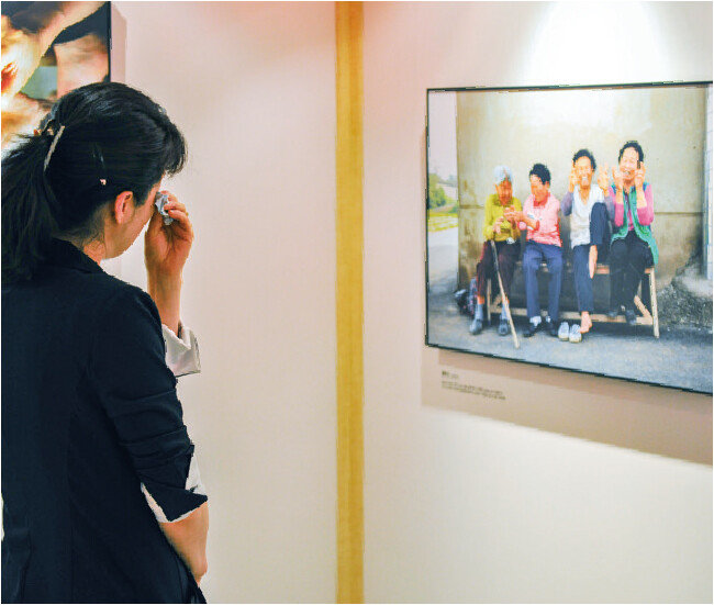 어머니전 작품을 관람하며 눈물을 훔치는 내방객.