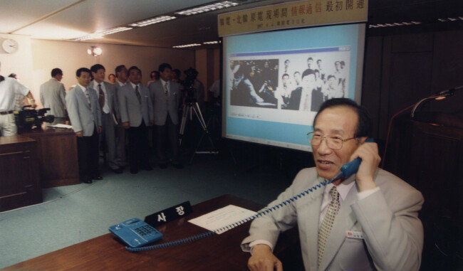 1997년 8월 4일 이종훈 한국전력 사장이 서울 삼성동 한전 본사에서 남·북 간 첫 민간직통회선으로 북한 신포 원전 현장과 통화하고 있다. 뒤편 화상에는 이 사장(왼쪽)과 이현주 한반도에너지개발기구(KEDO) 한국 측 대표의 통화 모습이 보인다. [동아DB]