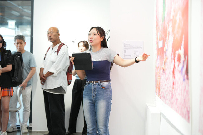 8일 인사동 마루아트센터 코리안드림 아트전시회에서 문지선 도슨트가 선무 작가의 작품 ‘들 놀이’에 대해 설명하고 있다. [글로벌피스재단]
