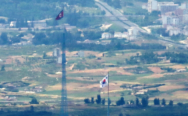 2021년 6월 16일 경기 파주시 접경지역에서 바라본 서부전선 비무장지대(DMZ)에 인공기와 태극기가 나란히 펄럭이고 있다. [뉴스1]