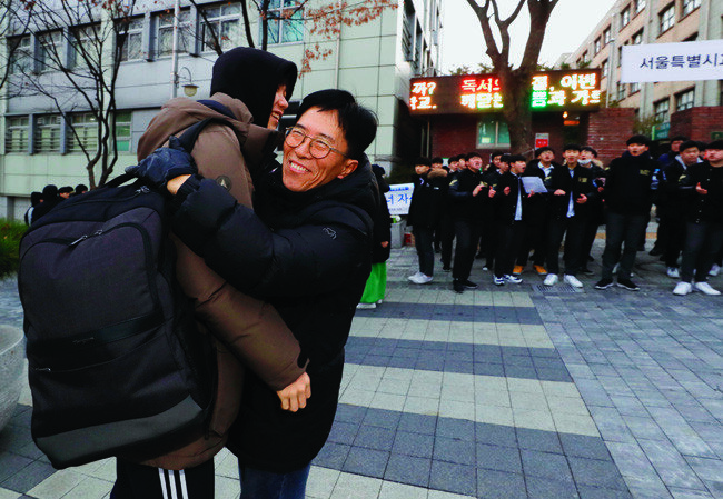 한 교사가 양재고 고사장 앞에서 기다리다 제자들을 한 명씩 포옹하며 응원하고 있다. 