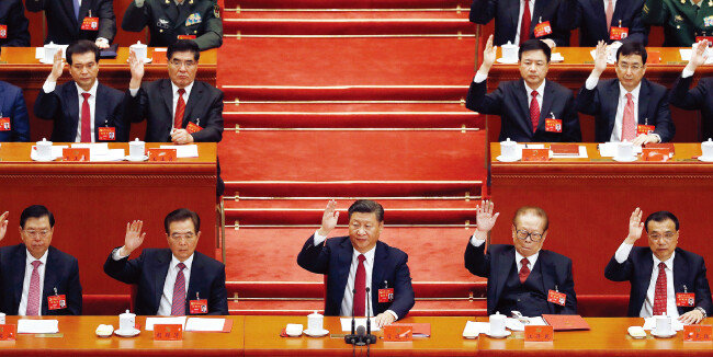 중국 베이징 인민대회당에서
 열린 제19차 중국 공산당 전국대표대회 폐회식에서 시진핑(앞줄 가운데) 국가주석 등이 손을 들어 업무보고 내용을 승인하고 있다. [뉴시스]