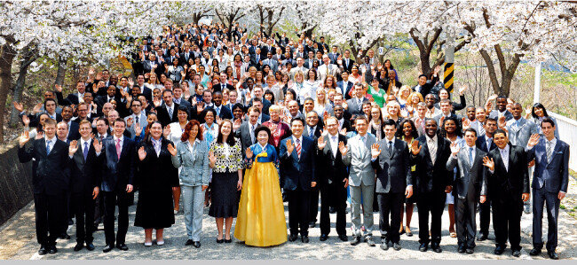북미, 유럽 대륙에서 온 제57차 해외성도방문단이 엘로힘연수원의 화사한 벚꽃 아래에서 환하게 웃고 있다.