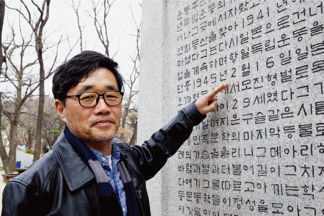 기형도의 절친이던 김태연 소설가가 연세대 신촌캠퍼스 내 윤동주 시비 뒷면에 적힌 윤동주의 기일을 가리키고 있다. 2월 16일은 기형도의 음력 생일이다. 또 그 아래 윤동주가 숨진 나이가 29세였다고 적혀 있는데 기형도 역시 29세에 숨졌다. [홍중식 기자]