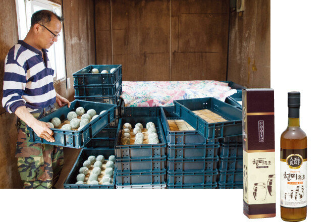 정재춘 대표가 쌀로 빚은 누룩(이화곡)을 보여주고 있다(왼쪽). 인양양초장 현미흑초. [조영철 기자]