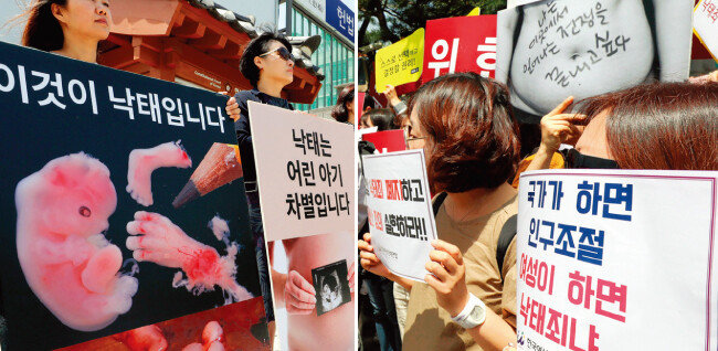5월 24일 서울 종로구 헌법재판소 앞에서 각각 낙태죄 합헌과 위헌 판결을 촉구하는 시민단체 회원들이 손팻말을 들고 대립하고 있다. [뉴시스]