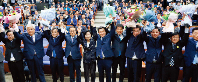6·13 전국동시지방선거와 함께 치른 국회의원 재·보궐선거에서 선출된 더불어민주당 당선인 11명이 6월 14일 서울 여의도 국회에서 열린 환영행사에서 더불어민주당 추미애 대표(가운데)와 만세를 하며 감사 인사를 하고 있다. [뉴스1]