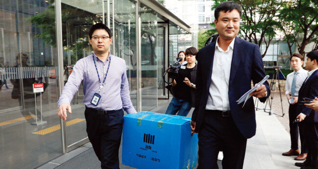 삼성증권의 배당 오류를 수사 중인 검찰이 5월 28일 오후 서울 서초구 삼성증권 본사를 압수수색한 뒤 압수품을 들고 건물을 나서고 있다. [뉴시스]