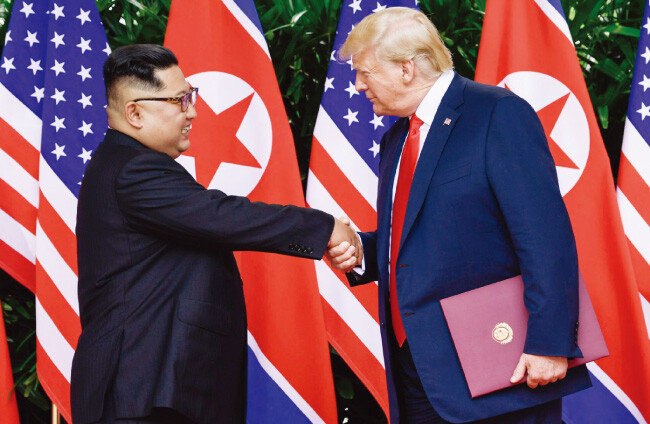 6월 12일 싱가포르 센토사섬 카펠라 호텔에서 열린 북·미 정상회담을 마치고 도널드 트럼프 미국 대통령(오른쪽)과 김정은 북한 국무위원장이 악수하며 작별 인사를 하고 있다. [싱가포르=AP 뉴시스]