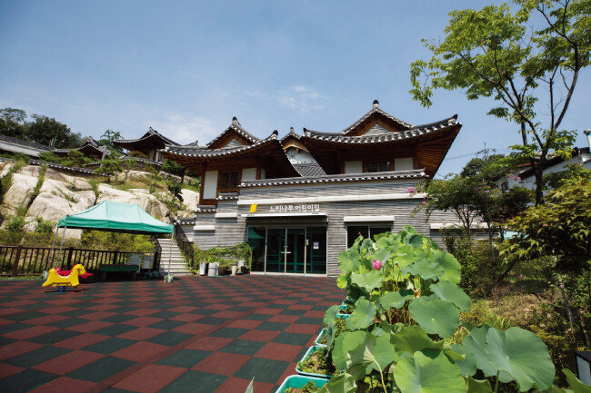 지하 1층의 앞마당. 왼편에 놀이터가 있고 오른편으로 연잎이 무성하다.