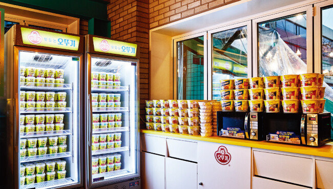 오뚜기와 KT가 컬래버레이션 한 덕에 식당 이용료를 낸 방문객은 오뚜기 컵밥과 라면, 떠먹는 컵피자 등을 무제한으로 즐길 수 있다(위). 식당 한쪽에 전시된 조형물과 캐릭터 인형들.