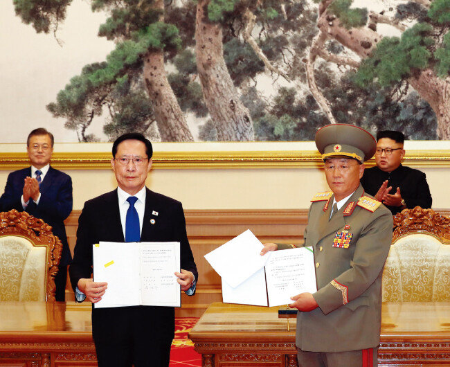 문재인 대통령과 김정은 국무위원장이 9월 19일 백화원 영빈관에서 송영무 국방부 장관과 노광철 인민무력상의 판문점 선언 이행을 위한 군사 분야 합의문 교환을 지켜보며 박수를 치고 있다. [평양사진공동취재단]