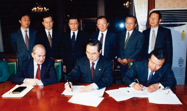 1997년 12월 3일 서울 종로구 정부종합청사(현 정부서울청사)에서 미셸 캉드쉬 국제통화기금 총재(아랫줄 왼쪽)가 지켜보는 가운데 임창열 당시 경제부총리 겸 재정경제원 장관(아랫줄 가운데)이 구제금융 합의서에 서명하고 있다. [동아DB]
