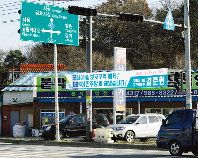 누산리 사거리에 이번 군사시설보호구역 해제를 축하하는 더불어민주당 김포지역위원장의 현수막이 내걸려 있다. [박해윤 기자]