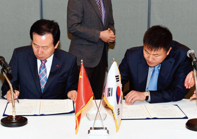 2015년 12월 쑹치 빠오화스예그룹 회장(오른쪽)이 목포시와 투자협력 양해각서를 체결하고 있다. 왼쪽은 박홍률 당시 목포시장. [목포시청 홈페이지]