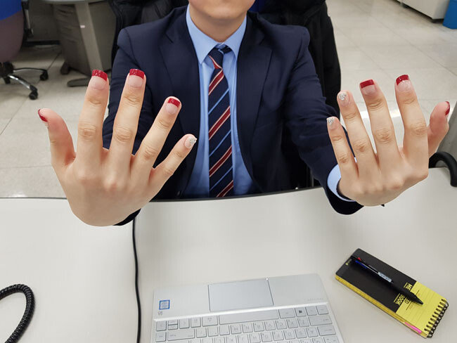네일아트를 마친 기자의 손. 강한 붉은 색감의 프렌치 네일아트로 새끼손가락에는 큐빅으로 포인트를 줬다.